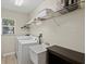 Functional laundry room with a sink, washer, dryer, and shelving at 23 Pine Valley Ct, Rotonda West, FL 33947