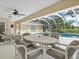 Screened patio features a dining area and lounge chairs overlooking the pool at 23 Pine Valley Ct, Rotonda West, FL 33947
