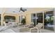 Relaxing screened patio with lounge chairs, a dining area, and a ceiling fan at 23 Pine Valley Ct, Rotonda West, FL 33947