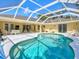 Inviting pool area with plenty of room for dining and lounging under the screened enclosure at 23 Pine Valley Ct, Rotonda West, FL 33947