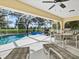 Inviting in-ground pool with a screened enclosure, lounge chairs, and scenic views at 23 Pine Valley Ct, Rotonda West, FL 33947