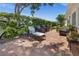 Enjoy this back patio with brick pavers, lush landscaping, and comfortable seating for relaxing outdoors at 237 Park Forest Blvd, Englewood, FL 34223