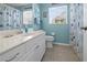 The bathroom has a modern sink, toilet, and shower/tub combination with stylish blue walls and seashell decor at 237 Park Forest Blvd, Englewood, FL 34223