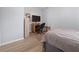A simple bedroom with a dark bed, wood floors, a TV, a desk, and a gray color scheme for a clean and modern aesthetic at 237 Park Forest Blvd, Englewood, FL 34223