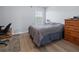 This bedroom has gray walls, a wood floor, a dark bed, and a bright window for a clean and simple design at 237 Park Forest Blvd, Englewood, FL 34223