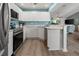 Kitchen with white cabinets, stainless appliances, wood flooring and view to the living space at 237 Park Forest Blvd, Englewood, FL 34223