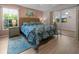 Bright bedroom with a tropical themed comforter, wood floors, and sliding door to lanai at 237 Park Forest Blvd, Englewood, FL 34223