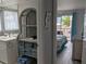 Bathroom view leading to bedroom, shows a vanity, shelves and a glimpse of bedding and deck at 2373 N Beach Rd # 1C, Englewood, FL 34223