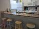 Functional kitchen with stainless steel sink, counter seating, and modern appliances at 2373 N Beach Rd # 1C, Englewood, FL 34223