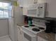 Well-equipped kitchen with modern appliances, white cabinets, and a bright window at 2373 N Beach Rd # 1C, Englewood, FL 34223