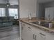 Stylish kitchen adjacent to living area, complete with modern white cabinets and sleek countertops at 2373 N Beach Rd # 1C, Englewood, FL 34223