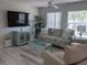 Cozy living room featuring a comfortable sofa, modern furniture, and plenty of natural light at 2373 N Beach Rd # 1C, Englewood, FL 34223