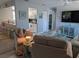 Relaxing living room featuring open access to kitchen, television, and comfortable sofas at 2373 N Beach Rd # 1C, Englewood, FL 34223