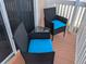 Cozy patio with cushioned wicker chairs and glass-top table, perfect for outdoor relaxation at 2373 N Beach Rd # 1C, Englewood, FL 34223