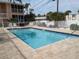 Inviting in-ground swimming pool with paver deck, surrounded by a secure white fence and tropical landscaping at 2373 N Beach Rd # 1C, Englewood, FL 34223