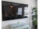 Mounted television above a wicker storage unit in a relaxing living room area at 2373 N Beach Rd # 1C, Englewood, FL 34223