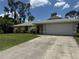 Charming single-story home with a well-maintained lawn and a two-car garage at 2473 Woodyglen St, Port Charlotte, FL 33948