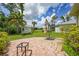 A backyard features a brick patio, an umbrella stand, and some greenery, offering relaxation and charm at 2588 Westberry Ter, North Port, FL 34286