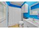 Bathroom with blue walls features a white vanity, toilet, and shower with curtain at 2588 Westberry Ter, North Port, FL 34286