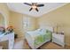 Cozy bedroom with white furniture, ceiling fan, and natural light from the window at 2588 Westberry Ter, North Port, FL 34286