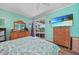 Bright bedroom boasts sliding glass door to pool, wood floors and coastal decor at 2588 Westberry Ter, North Port, FL 34286