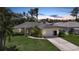 Charming single-story home with a well-manicured lawn, mature trees, and a two-car garage at 2588 Westberry Ter, North Port, FL 34286