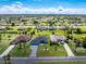 Expansive aerial view of a residential neighborhood featuring single-Gathering homes and landscaped lawns under a partly cloudy sky at 262 Rotonda N Blvd, Rotonda West, FL 33947