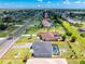 Aerial view of a home featuring a pool and bordered by green lawns, with a road in the background at 262 Rotonda N Blvd, Rotonda West, FL 33947