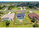 Aerial view of a property featuring a pool, surrounded by green space and neighboring houses in a residential area at 262 Rotonda N Blvd, Rotonda West, FL 33947
