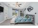 Bright bedroom featuring a ceiling fan, bed with floral comforter and access to the pool at 262 Rotonda N Blvd, Rotonda West, FL 33947