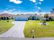Beautiful light blue single-story home with a well-manicured lawn and a long driveway leading to an attached two-car garage at 262 Rotonda N Blvd, Rotonda West, FL 33947