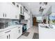 Kitchen featuring white cabinets, stainless appliances, island with sink and adjacent dining area at 262 Rotonda N Blvd, Rotonda West, FL 33947