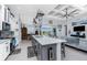 Open kitchen with white cabinetry, stainless steel appliances, island and views into the living room at 262 Rotonda N Blvd, Rotonda West, FL 33947