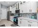 Well-appointed kitchen featuring white cabinets, stainless steel appliances, modern countertops, and tile backsplash at 262 Rotonda N Blvd, Rotonda West, FL 33947