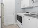 Functional laundry room with modern appliances, storage cabinets and a door at 262 Rotonda N Blvd, Rotonda West, FL 33947