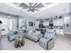 Inviting living room with tray ceilings, modern fan, tile floors, and comfortable seating flowing into the kitchen area at 262 Rotonda N Blvd, Rotonda West, FL 33947