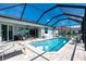 A beautiful screened-in pool featuring clear blue water and lounge chairs for backyard relaxation at 262 Rotonda N Blvd, Rotonda West, FL 33947