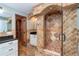 Luxurious bathroom featuring a beautiful tile shower, granite countertop and custom wood vanity at 26294 Bridgewater Rd, Punta Gorda, FL 33983