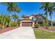 Charming two-story home with tropical landscaping, a wide driveway, and a two-car garage at 26294 Bridgewater Rd, Punta Gorda, FL 33983