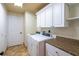 Laundry room equipped with modern washer and dryer units, ample cabinet space, and a convenient folding area at 26294 Bridgewater Rd, Punta Gorda, FL 33983