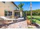 Relaxing outdoor patio with brick pavers, string lights, comfortable seating, and a charming fireplace at 26294 Bridgewater Rd, Punta Gorda, FL 33983