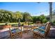 Inviting brick patio featuring stylish outdoor seating, a cozy fire pit, and beautiful landscaping at 26294 Bridgewater Rd, Punta Gorda, FL 33983