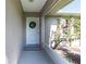 Cozy covered entry featuring a classic white front door adorned with a festive wreath and neutral accents at 3085 Crowder St, Punta Gorda, FL 33980