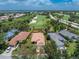 Aerial view of a home with a red boundary line, surrounded by lush greenery and a golf course at 3207 Village Ln, Port Charlotte, FL 33953