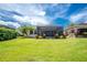 Expansive backyard with a screened-in lanai and lush landscaping at 3207 Village Ln, Port Charlotte, FL 33953
