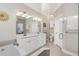 Clean bathroom with shower, separate tub, and double vanity, all accented by neutral colors at 3207 Village Ln, Port Charlotte, FL 33953