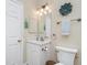 Well-lit bathroom featuring white cabinets, a white toilet, and nautical themed décor at 3207 Village Ln, Port Charlotte, FL 33953