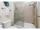 Well-lit bathroom featuring a glass shower door with a tile surround and a white toilet at 3207 Village Ln, Port Charlotte, FL 33953