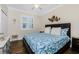 Comfortable bedroom with wood floors, white trim, ceiling fan and a large window with plantation shutters at 3207 Village Ln, Port Charlotte, FL 33953