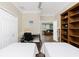 Bedroom featuring two twin beds, wood floors, and views of the open living area at 3207 Village Ln, Port Charlotte, FL 33953